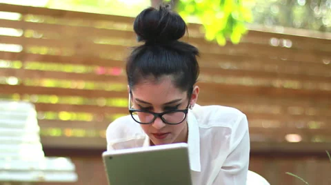 Girl using iPad tablet technology in the park 03 Stock Footage 39570463