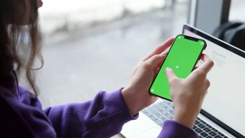Girl using iPhone 12 smartphone viewing green screen on phone press browsing 스톡 동영상 169478527