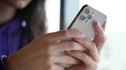 Girl using iPhone 12 smartphone pressing finger, reading social media internet Stock Footage 169478548