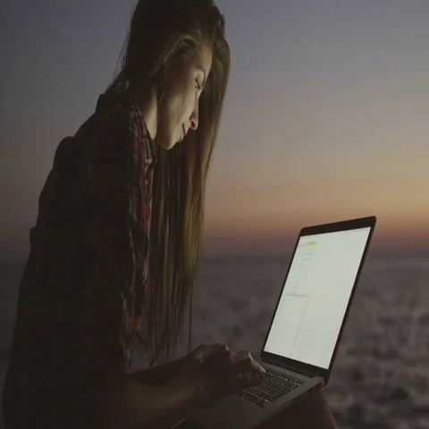 Girl using laptop at the beach Stock Footage 69464704