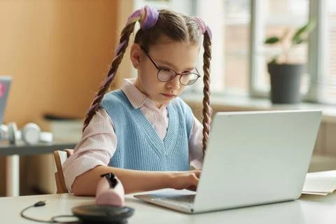 Girl using laptop computer in class during programming lesson for kids Stock Photos