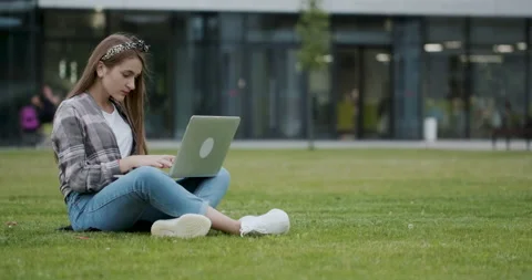 Girl using a laptop computer to look up information on the internet. A pretty Stock Footage 195275142