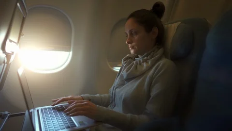 Girl using laptop while is sitting in plane Stock Footage 109570099