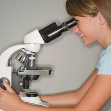 Girl using microscope Foto stock