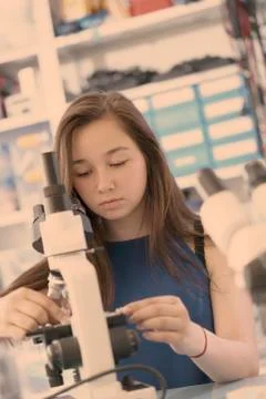 Girl using microscope Stock Photos
