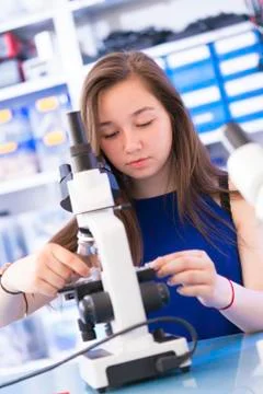 Girl using microscope Stock Photos