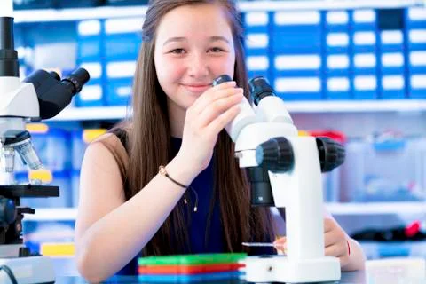 Girl using microscope Stock Photos