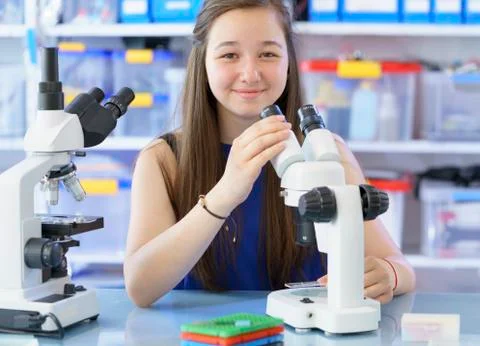 Girl using microscope Stock Photos