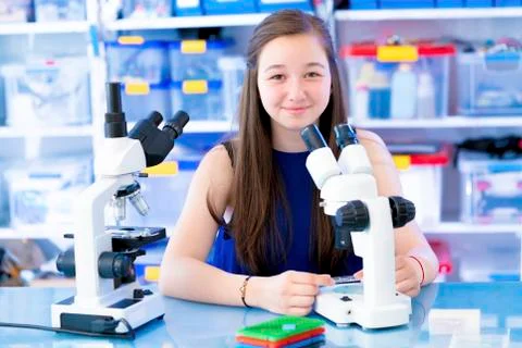 Girl using microscope Stock Photos