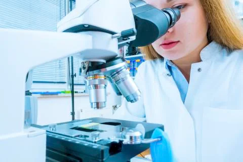 Girl using microscope Stock Photos