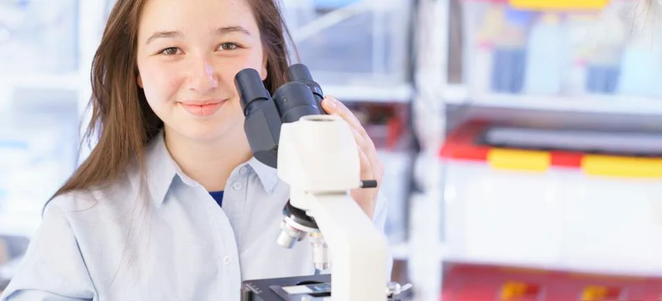 Girl using microscope Stock Photos
