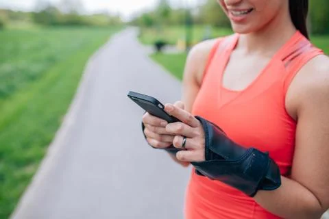 Girl is using mobile phone after workout. Close up. Stock Photos