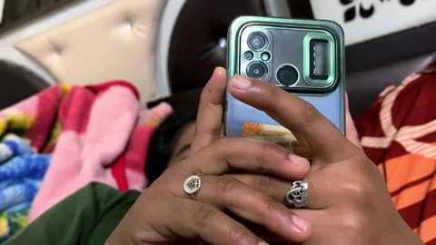 Girl Using Mobile Phone While Lying in Bed Stock-Footage 319977791