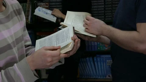 Girl using phone and two boys reading books in the library Video stock 86825675