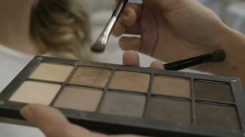 Girl is using powder to make her girlfriend up Stock Footage 85535543