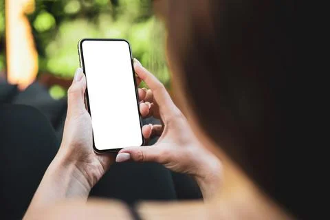 Girl using smartphone blank screen frameless modern design while lying on the Stock Photos