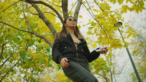 Girl Using Smartphone Chewing Bubble Gum And Blowing Red Helium 8K Stock Footage 142669123