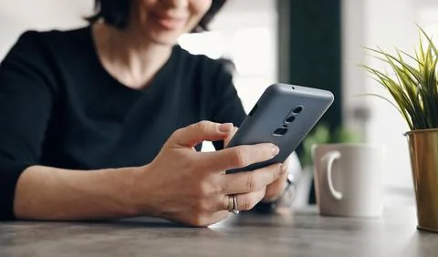 Girl Using A Smartphone In The Kitchen Foto stock