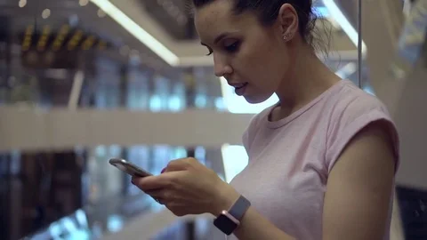 Girl using smartphone in a moving elevator. Beautiful bokeh Stock Footage 78605226
