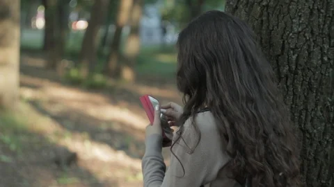 A girl is using a smartphone in the park Stock Footage 90752001