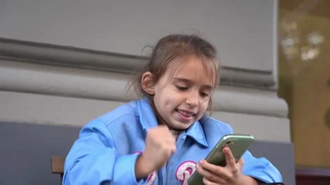 The girl using smartphone. playing games or looking information. Child and ga Stock Footage 254585928
