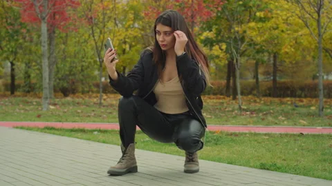 Girl Using Smartphone Posing For Selfie Photo in the park Red Helium 8K Stock Footage 142641320