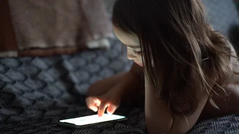 Girl using smartphone, using mobile apps, playing games at home Stock Footage 223351887