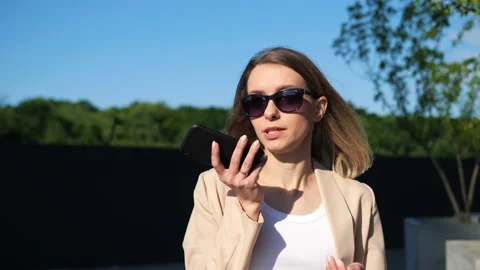 Girl using smartphone voice recognition, dictation message, work task outdoor. Stock Footage 200945047