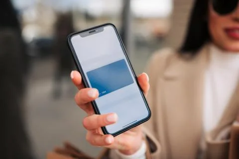Girl using smartphone while making contactless payment . Stock Photos