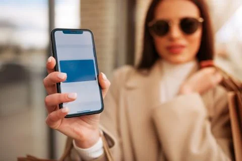 Girl using smartphone while making contactless payment . Stock Photos