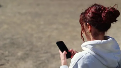 Girl using smartphone writing message scrolling news feed watching content Stock Footage 302764978