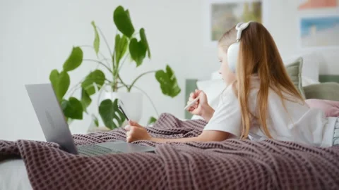 Girl using tablet and laptop while lying on bed Stock Footage 311918780