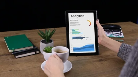 Girl Using a Tablet with animated Analityc vertical and Drinking coffee Stock Footage 107799879