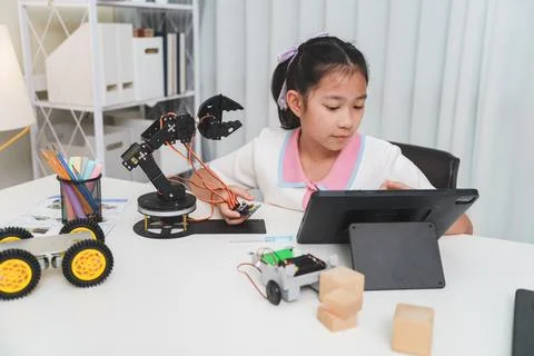 Girl using a tablet to code a robot. E-learning and STEM education concept. Foto stock