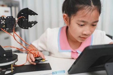 Girl using a tablet to code a robot. E-learning and STEM education concept. Foto stock