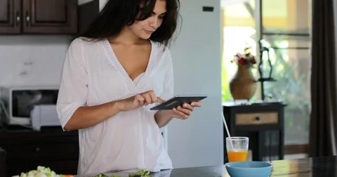 Girl Using Tablet Computer Chatting Online Cutting Vegetables, Young Woman Happy Stock Footage 75211295