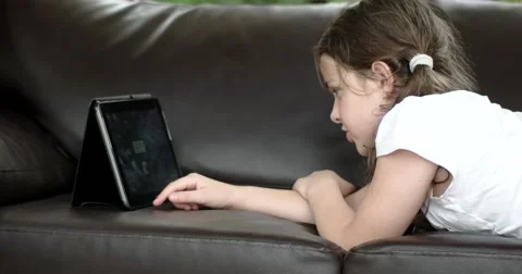Girl Using Tablet Computer Lying on Leather Sofa on Terrace 動画素材 64637507