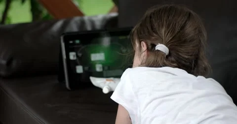 Girl Using Tablet Computer Lying on Leather Sofa on Terrace Stock Footage 64637672