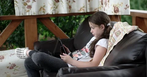 Girl Using Tablet Computer Lying on Leather Sofa on Terrace Vídeo Stock 64651075