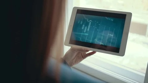 Girl using tablet computer tracks chart and the stock exchange in the background Stock Footage 83263779
