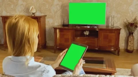 Girl Using Tablet In Front Of The TV 1 With Green Screen Stock Footage 58750323