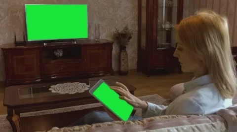 Girl Using Tablet In Front Of The TV 2 With Green Screen Stock Footage 58757712