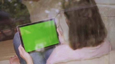 Girl using tablet with green screen in home Stock Footage 92386363