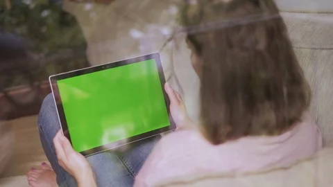 Girl using tablet with green screen in home, cute dog disturb Stock Footage 92386412