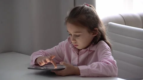 Girl Using Tablet. Intensely focused on a gadget.  school girl with tablet Stock Footage 277655850