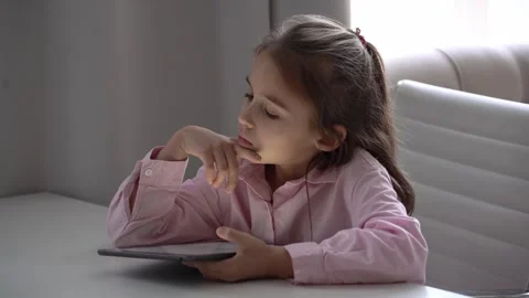 Girl Using Tablet. Intensely focused on a gadget. Caucasian school girl Stock Footage 278600061