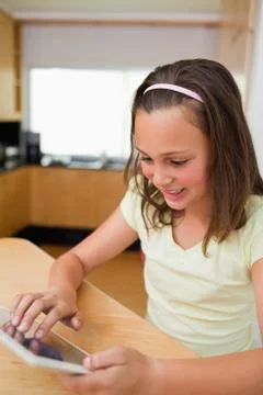 Girl using tablet at the kitchen table Foto stock