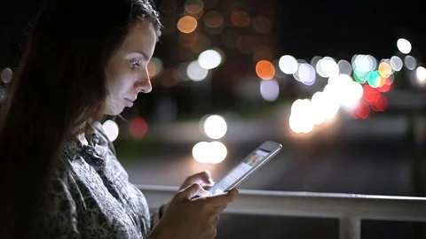 Girl using tablet on the night time on street Stock Footage