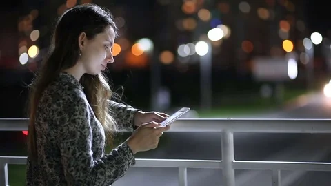Girl using tablet on the night time on street Stock Footage 77532140