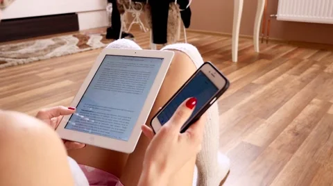 Girl using tablet pc and mobile phone. She is holding tablet pc. Video stock 61138668